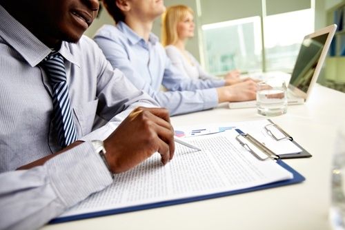 Employees at a table with notes and computers