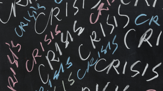 Crisis written on chalkboard in multiple colors